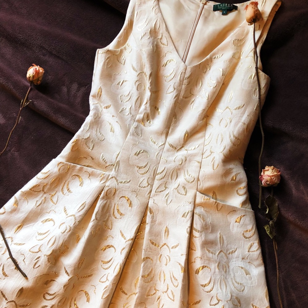 Cream knee length dress with gold patterns.